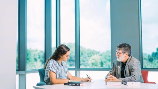 Professor and student at table